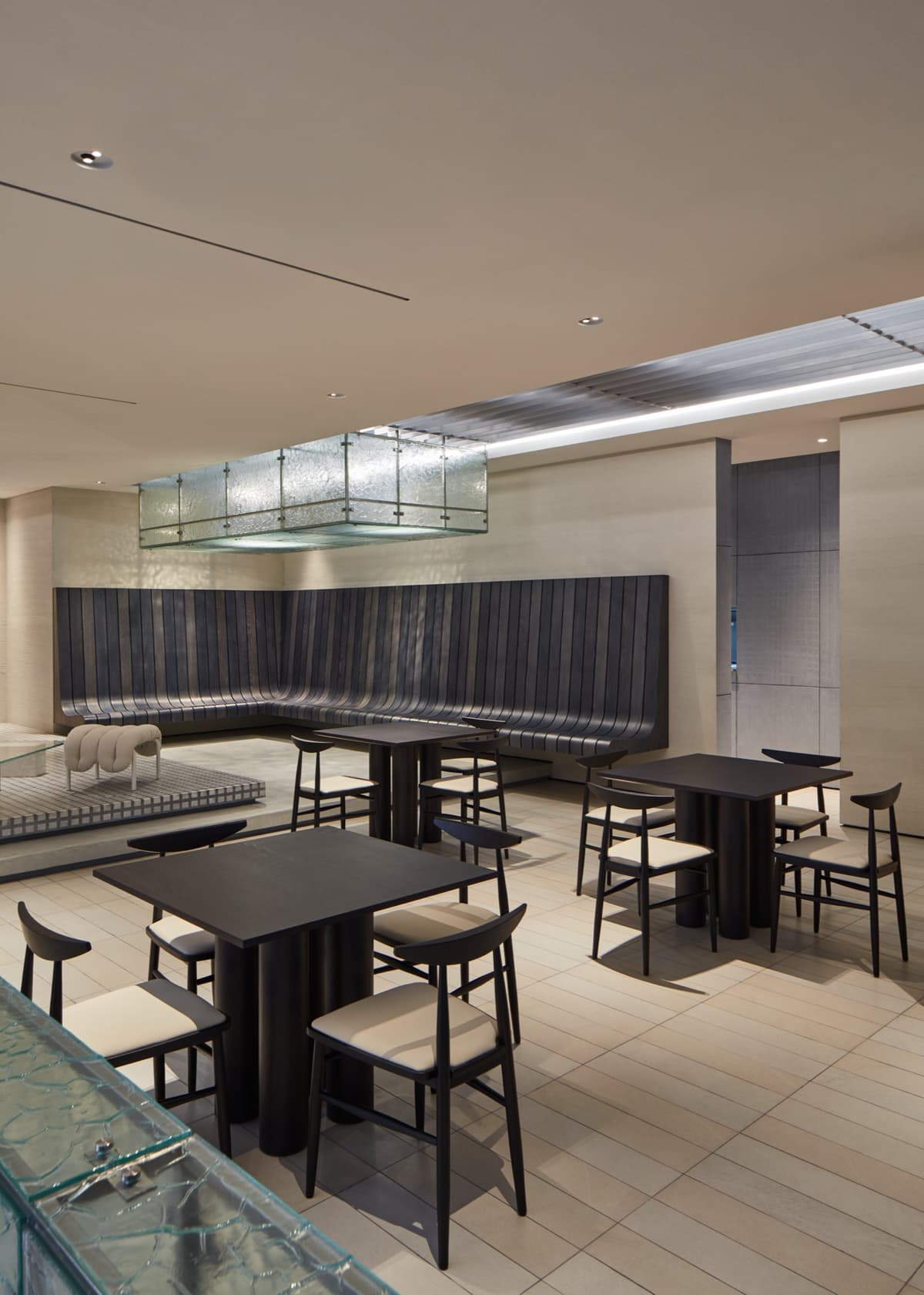 Dining room with charcoal timber banquette and glass lightbox